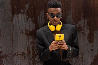A black ethnic man listening to music wireless yellow headphones