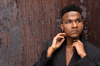 A black ethnic man in a fashion pose on a brown metallic background