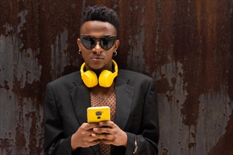 A black ethnic man listening to music yellow headphones