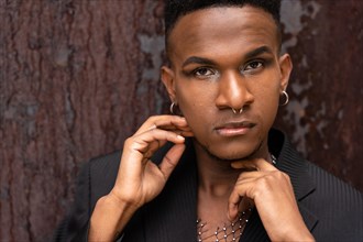 A male model of black ethnicity in a fashion pose on a brown metallic background