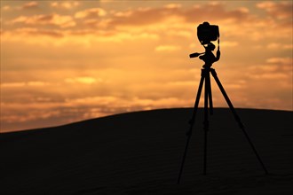 Photo camera and tripod in the desert of Dubai