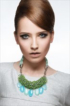 Beautiful fashionable girl with smooth hair and original decoration around her neck
