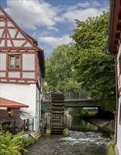 Half-timbered house with old mill wheel