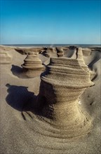 Wind-sculpted sand towers on beach by Mediterranean Sea