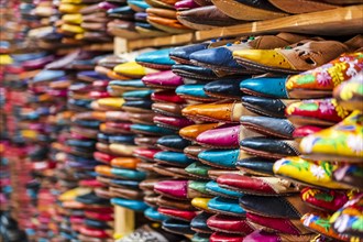 Colorful handmade leather slippers waiting for clients at shop in Fes