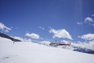 Red and white Swiss helicopter parks on Aletsch Glacier