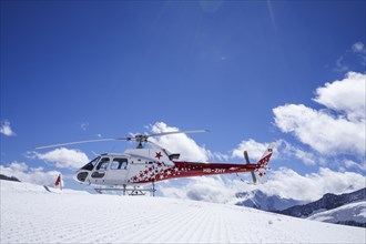 Swiss helicopter with red and white stars stands on Aletsch Glacier low angle view