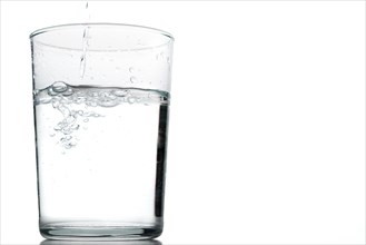 Close-up of a moving glass of crystal clear water isolated on a white background