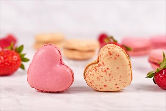 Two beige and pink heart shaped French macaron sweets