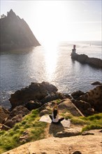 A woman doing yoga exercises in nature by the sea