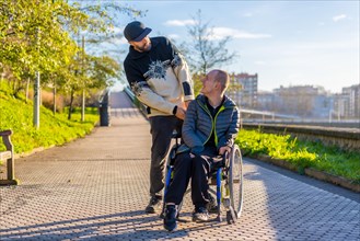 A disabled person in a wheelchair with an assistant enjoying a walk in the city