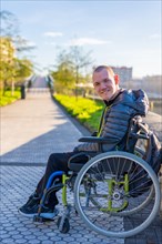 Portrait of a disabled person in a wheelchair in the city sunset