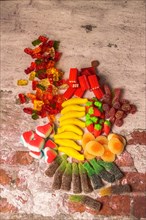 Several types of assorted jelly candies on a brick background