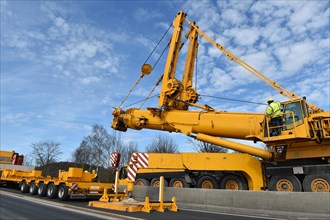 Truck-mounted crane and low loader on a construction site