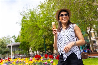 A tourist woman visiting the city eating an ice cream cone