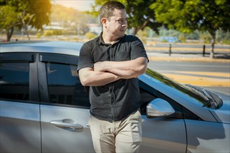 Man with crossed arms leaning on the car
