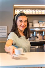 Female cafe owner with a latte in hand