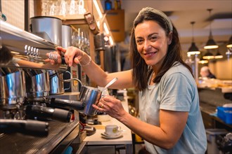 Female cafe owner preparing coffee in a coffee machine