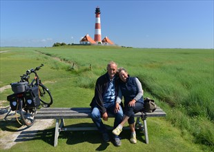 Couple sitting on a bench at Westerheversand lighthouse