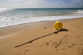 Yellow plastic buoy on the beach