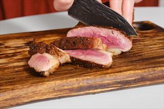 Closeup view of slicing grilled duck breast