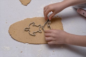 Close-up of childrens hands making cookie shapes with the help of cookie cutters