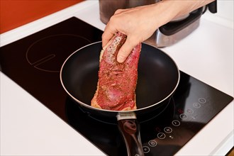Placing duck breast in a hot frying pan