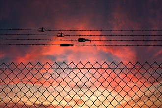 Chain link fence with additional barbed wire