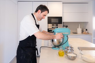 A man baker cooking a red velvet cake at home