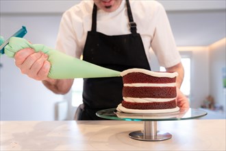 Hands of a man bakes a red velvet cake at home