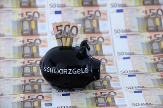 Piggy bank with the inscription black money and various 50 euro banknotes