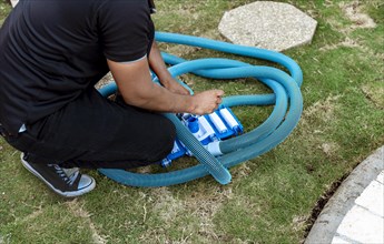 Man connecting the handle on the pool vacuum