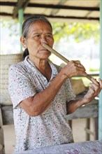 Malaysian woman playing a nose flute