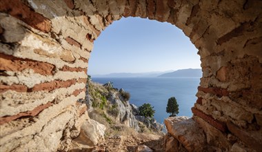 View of the sea through a window in the wall of the fortress of Palamidi