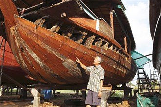 Thai boat builder showing one of his rice barges
