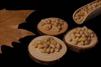 Pine nuts on slices of wood dried leaves and pine branch