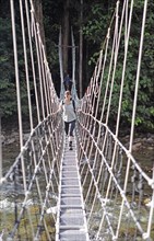 Woman crossing a suspension bridge