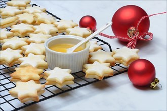 Christmas biscuits on cake rack and tray with lemon curd