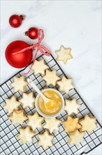 Christmas biscuits on cake rack and tray with lemon curd
