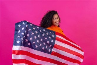 Curly-haired woman with the usa flag on a pink background