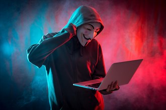 Hacker with an anonymous mask with a computer and making a fight symbol