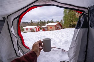 Having a coffee in a cup inside a tent on a winter morning