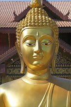 Golden Buddha figure in front of Wat Phra Bat Ming Muang