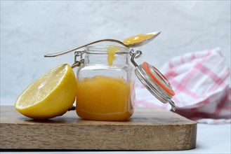 Glass jar with lemon curd and lemon