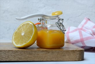 Glass jar with lemon curd and lemon