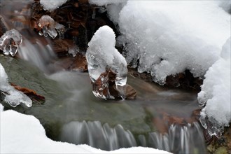 Long exposure of a stream in winter with ice and snow in the Hunsrueck-Hochwald National Park