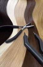 Strands of natural hair in different colors for extensions with tools