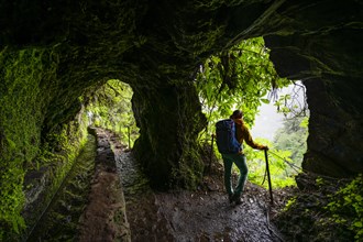 Hiker in a tunnel at PR9 Levada do Caldeirao Verde