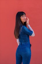 Posing of a brunette girl smiling in a denim outfit
