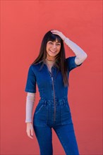 Posing of a brunette girl smiling in a blue denim outfit